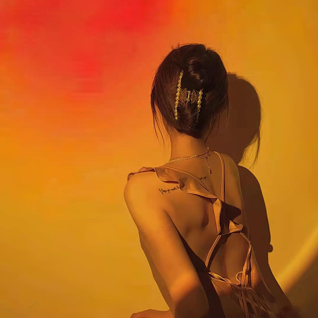 A sunset glow from this Clérachic projection lamp washes orange and red light across a woman's bare shoulders and back.
