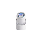 Seen from above, this white Clérachic projection lamp tilts its lens down, unlit, against a plain backdrop.