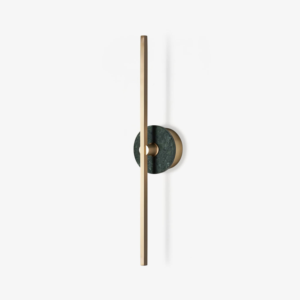 Clérachic wall sconce photographed alone on white, a slim brass bar crossed by a small green stone disc partway up.