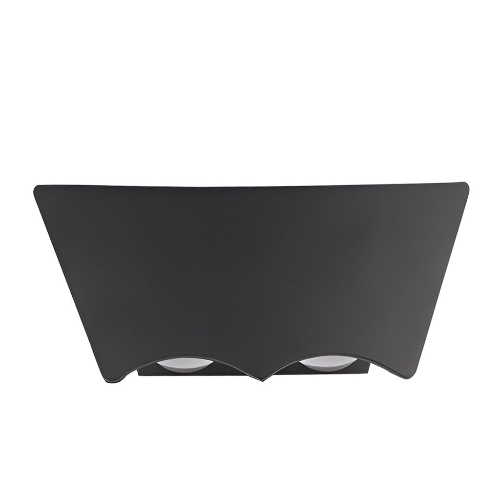 Front studio view of the unlit black sconce, its curved face and scalloped lower edge holding two lenses.