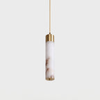 A close view of this Clérachic pendant's single alabaster tube, its warm veining lit beneath a brass cap.
