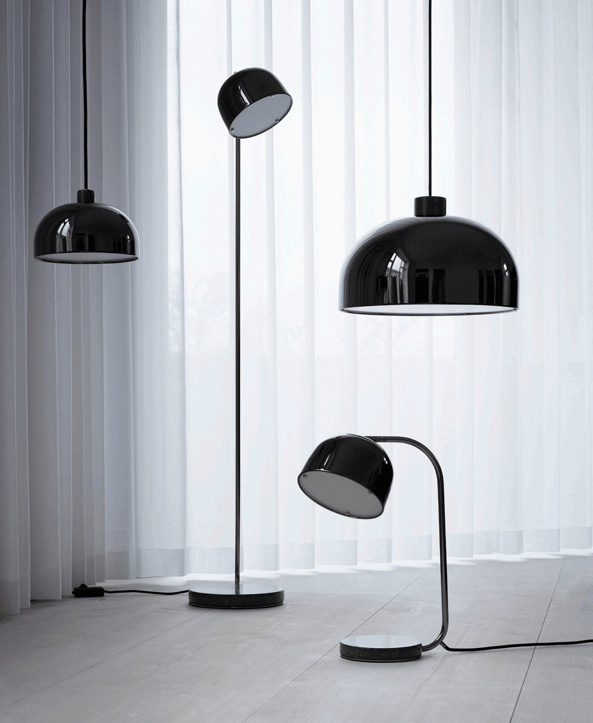Black dome-shade floor lamp from Clérachic grouped with two matching pendant lights on a white curtain backdrop.