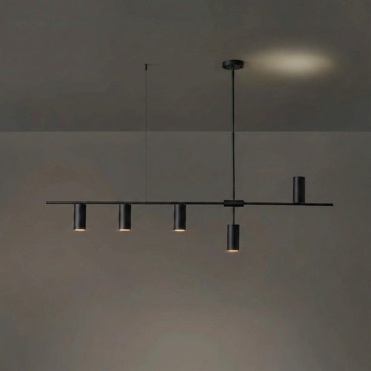 In the black finish, this Clérachic chandelier's rod and cylinder heads are uniformly dark, against a dim backdrop with a warm glow.