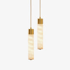 On a plain backdrop, this Clérachic pendant shows two alabaster tubes of different lengths capped in brass.