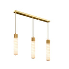 Suspended from a brass linear ceiling bar, this Clérachic pendant's three alabaster tubes hang evenly spaced.