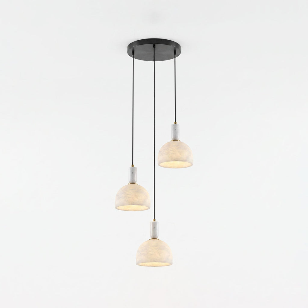 Three alabaster domes of this Clérachic pendant hang unlit at staggered heights from a shared round black ceiling plate.