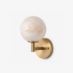 Cropped close on a plain background, this Clérachic sconce's brass arm curves upward to hold a single alabaster globe.