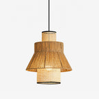 This Clérachic pendant, its tiered rattan drums skirted in jute rope fringe, shown glowing against a plain background.