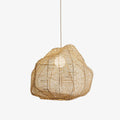 Studio view of this Clérachic pendant, its cross-hatched rattan cane wrapped around an exposed bulb.