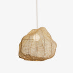 Studio view of this Clérachic pendant, its cross-hatched rattan cane wrapped around an exposed bulb.