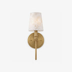 Product view of this Clérachic sconce in brass hardware, its tapered alabaster cone shade glowing on a plain backdrop.