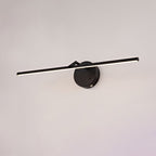 A black-finish Clérachic wall light shown unlit on a plain wall, its slim bar crossing the round canopy at an angle.