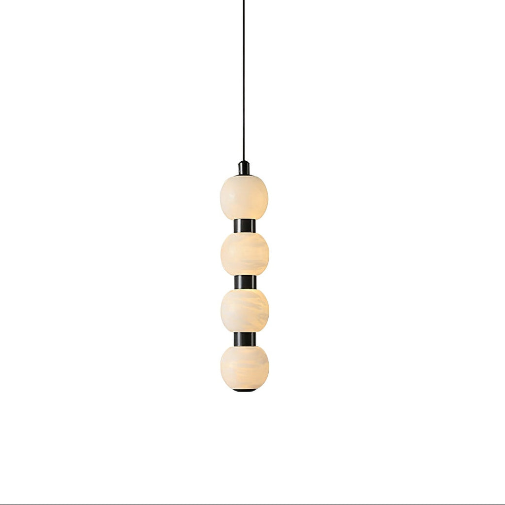 Orbique alabaster ball pendant light in its four-ball version, lit and hanging from a slim black cable