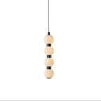 Orbique alabaster ball pendant light in its four-ball version, lit and hanging from a slim black cable