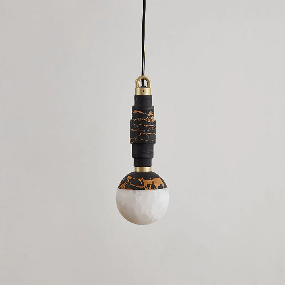 Black marble pendant lamp with gold veining and a pale alabaster globe shade, hanging unlit against grey.