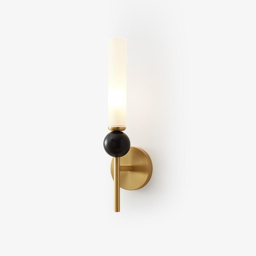 Slim frosted glass cylinder rising from a dark sphere on a brass disc, the Clérachic wall light shown against plain white.