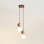 Two cords drop travertine and glass spheres at differing heights from this Clérachic pendant's round canopy, studio shot.