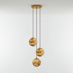 Three-light Sultana alabaster chandelier lit warm, its stone globes staggered below a round gold canopy.