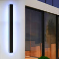 The fixture beside sliding glass doors, backlit with a cool blue-white glow on a white wall.