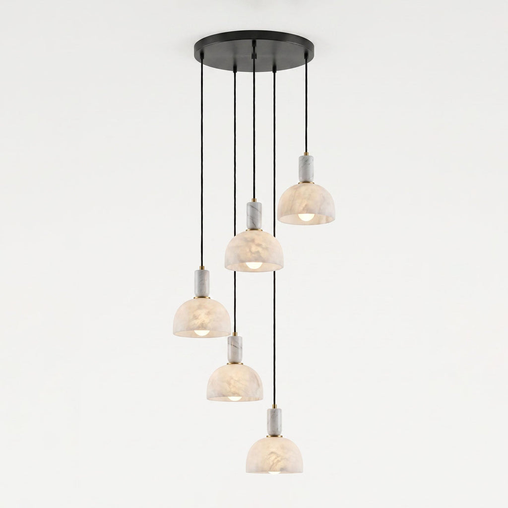 Five alabaster domes hang unlit at staggered lengths from one round black ceiling plate on this Clérachic multi-drop pendant.