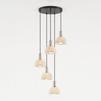 Five alabaster domes hang unlit at staggered lengths from one round black ceiling plate on this Clérachic multi-drop pendant.
