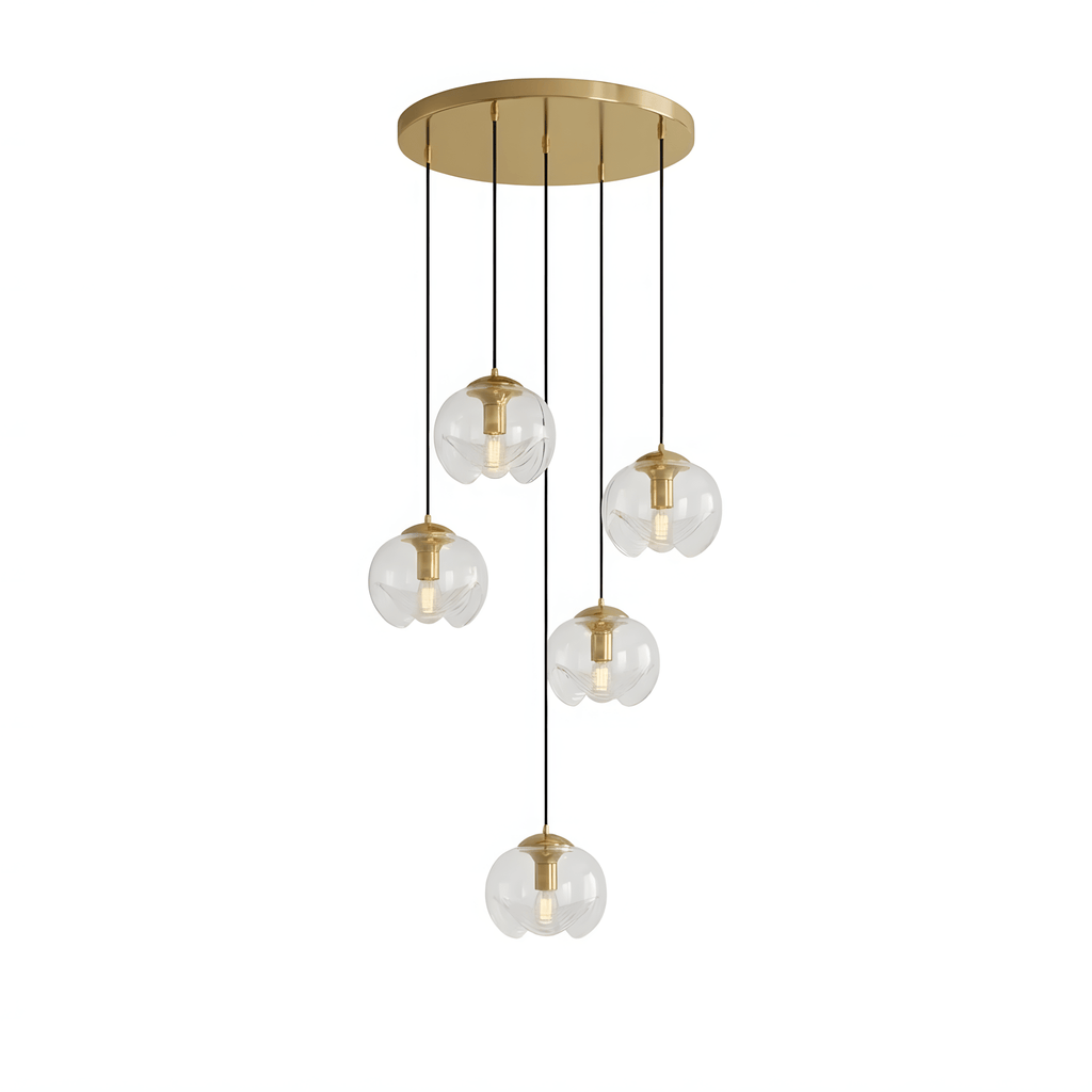 Six small round clear glass shades hang at staggered heights from a gold ceiling plate, this Clérachic fixture shown on white.