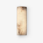 Alabaster wall light glowing softly in a styled interior