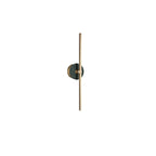 Clérachic wall light on white, a deep green stone disc set against its slender, full-length brass bar.