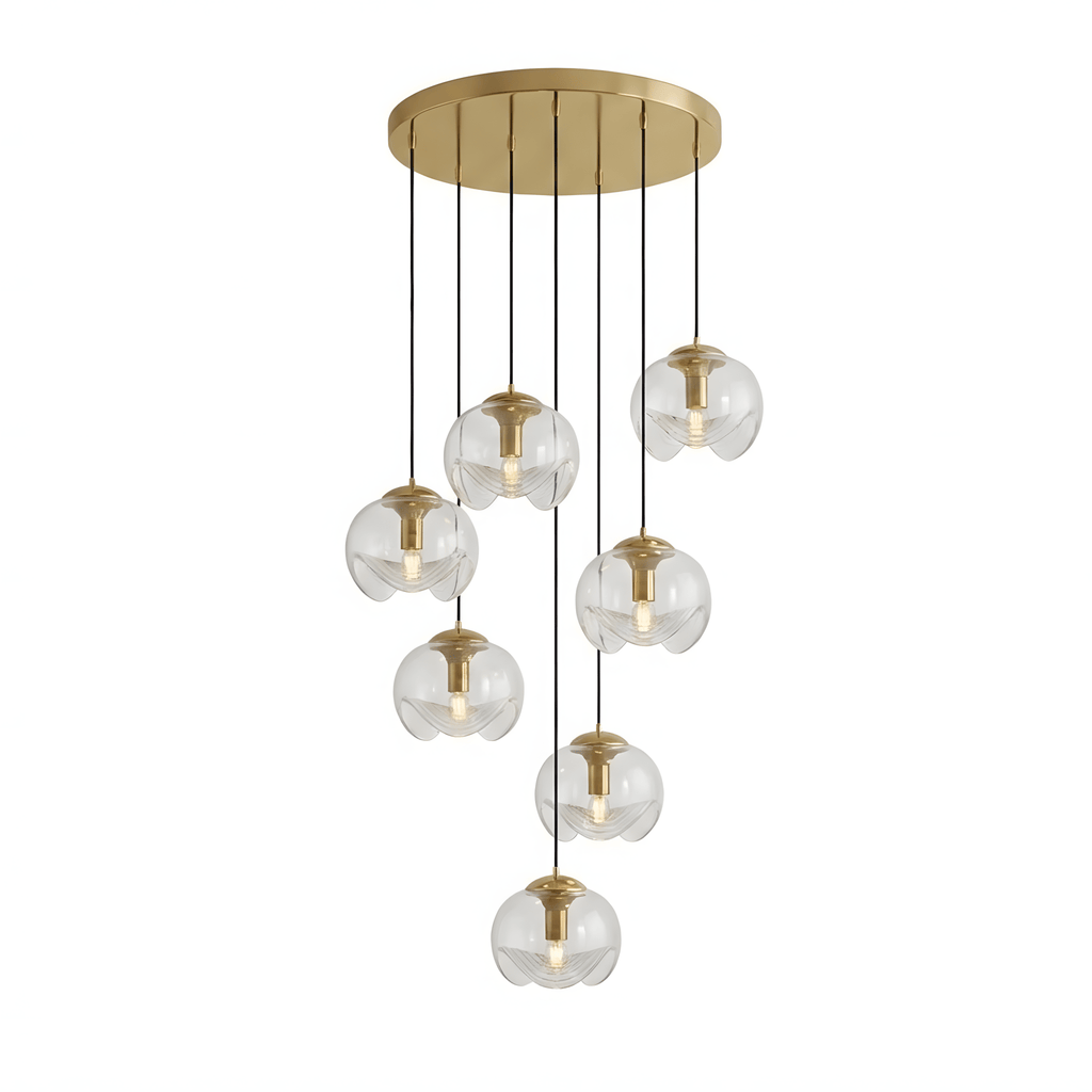 Clear glass shades spiral down from a gold ceiling plate in a dense cluster, this Clérachic fixture shown on a white background.