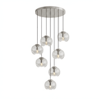 Round clear glass shades hang at varied heights from a silver ceiling plate, this Clérachic fixture shown on a white background.