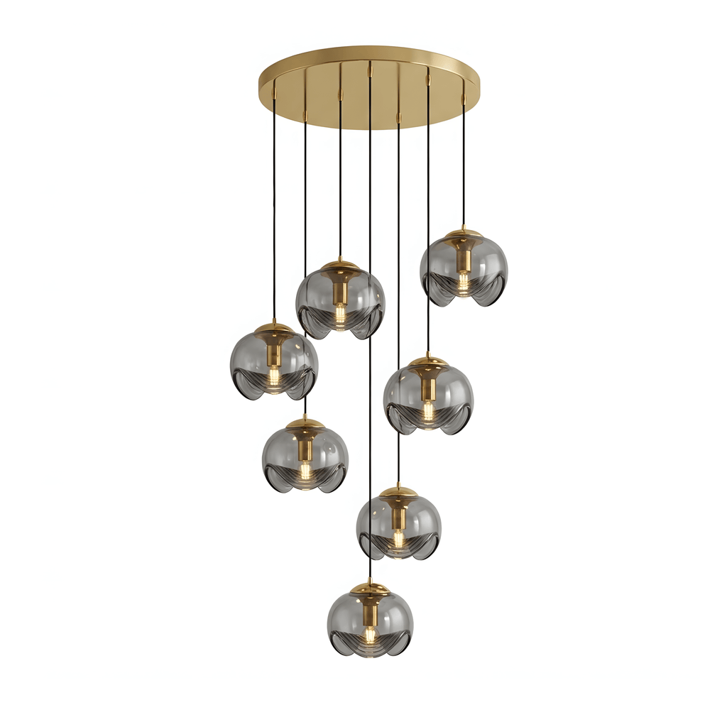 A tiered cluster of smoky grey glass shades hangs from a gold ceiling plate, this Clérachic fixture shown on a white background.