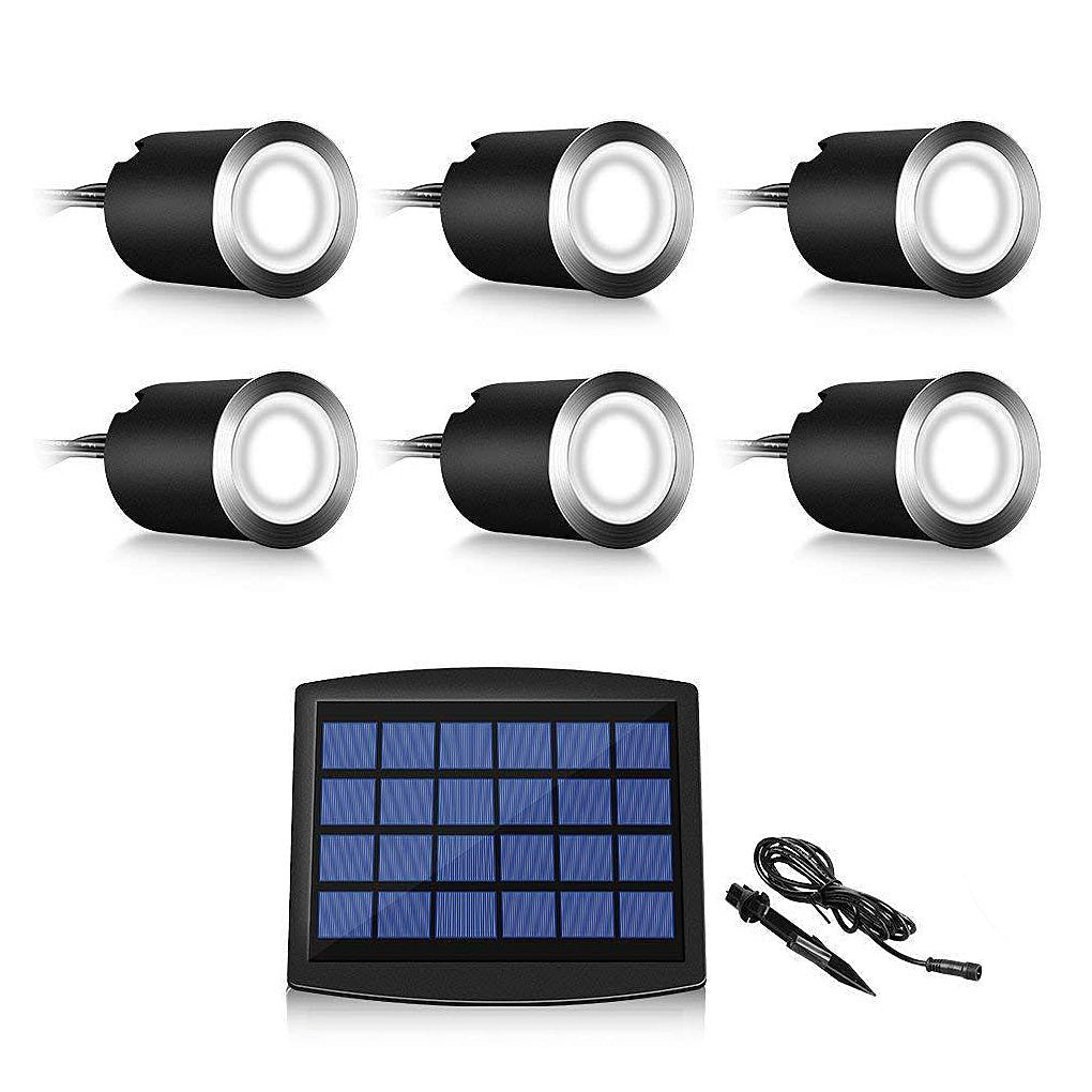 Kit contents laid out on white: six recessed lights with cables and one solar panel on a ground spike.