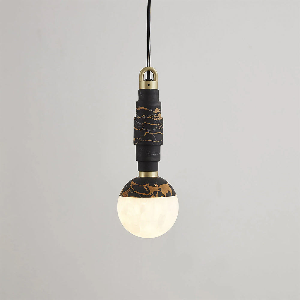 Black-and-gold marble pendant switched on, light glowing through the lower half of the alabaster globe.
