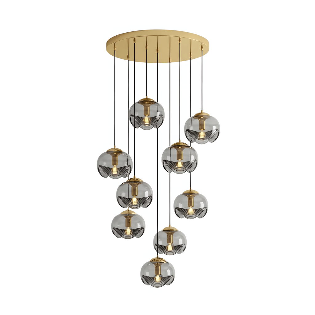 A dense cluster of smoky grey glass shades drops from a gold ceiling plate, this Clérachic fixture shown on a white background.