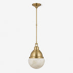 Studio shot of this Clérachic pendant in brushed brass, with its alabaster ball shade and slender stem.