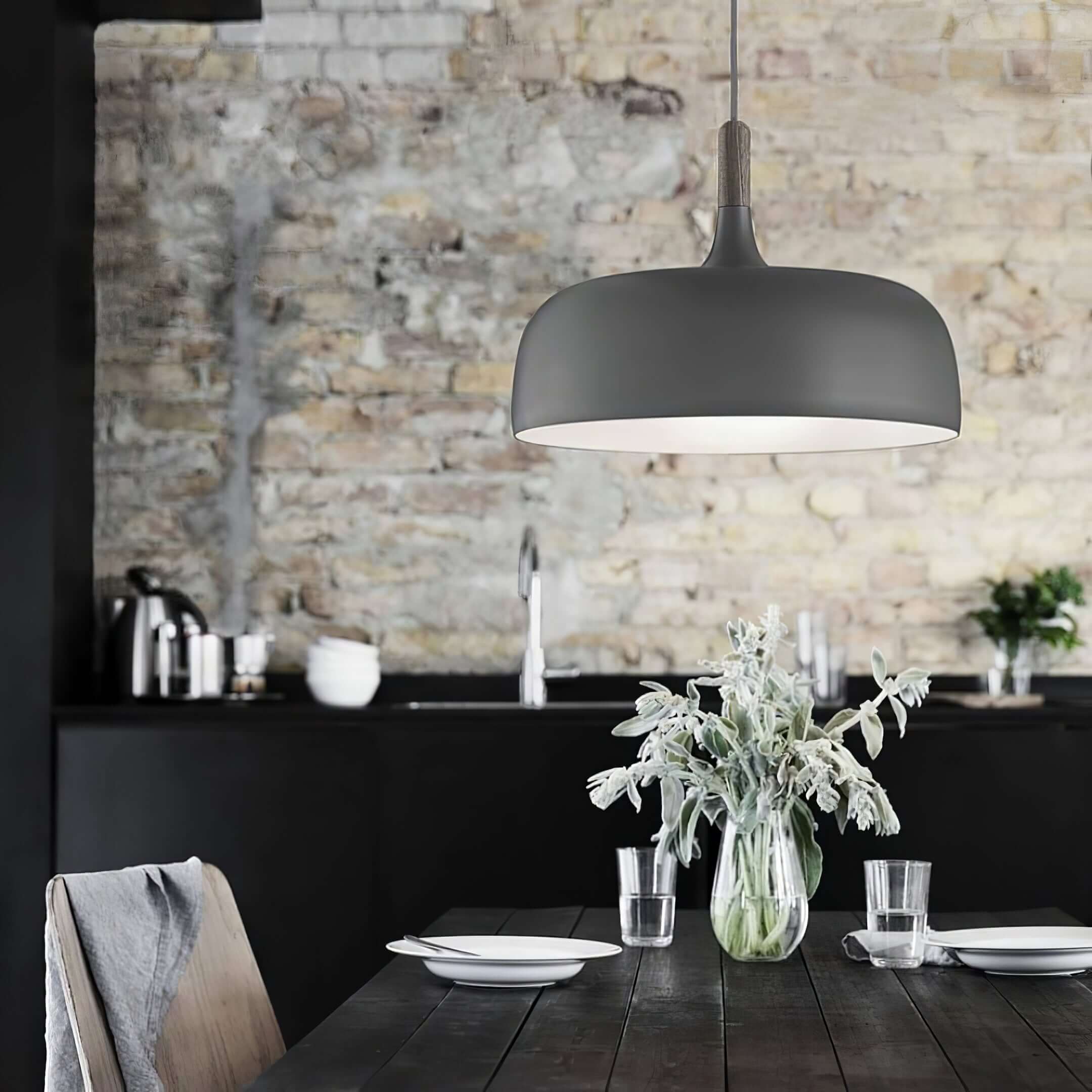 Acorn pendant light hanging low over a wooden tabletop