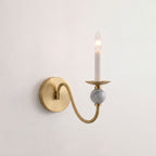 Shown from the side on a white backdrop, this Clérachic wall light traces its brass arm down to the marble ball.