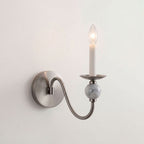 Isolated on white, this Clérachic wall light shows a brushed-nickel arm curving down to a marble ball.