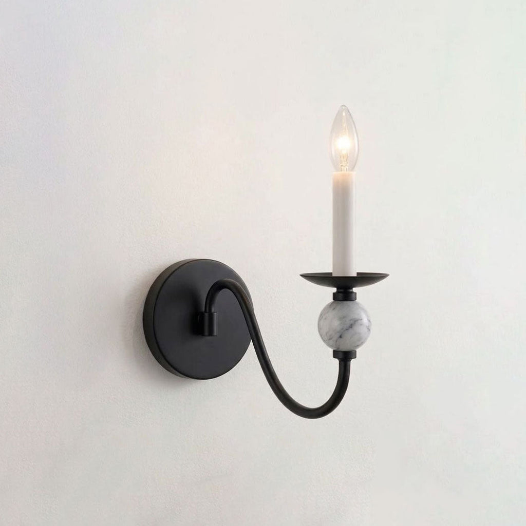 Alone on white, this Clérachic wall light shows its matte-black S-curve arm holding a lit candle bulb.