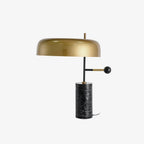 Clérachic's gold dome table lamp photographed straight-on against white, its black marble base fully in view.