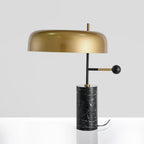 This angle catches a bright reflection across the Clérachic lamp's glossy gold dome shade on a white background.