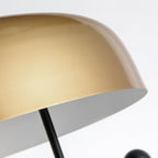 An extreme close-up of the underside of the Clérachic lamp's gold dome shade, showing its curved metal surface.