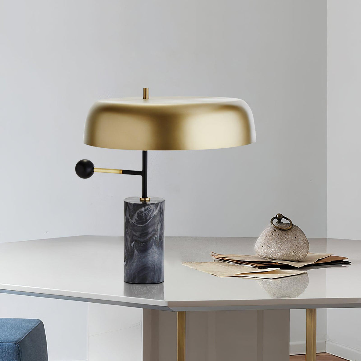 This Clérachic table lamp sits on a grey marble tabletop beside an open notebook and a small ceramic dish.