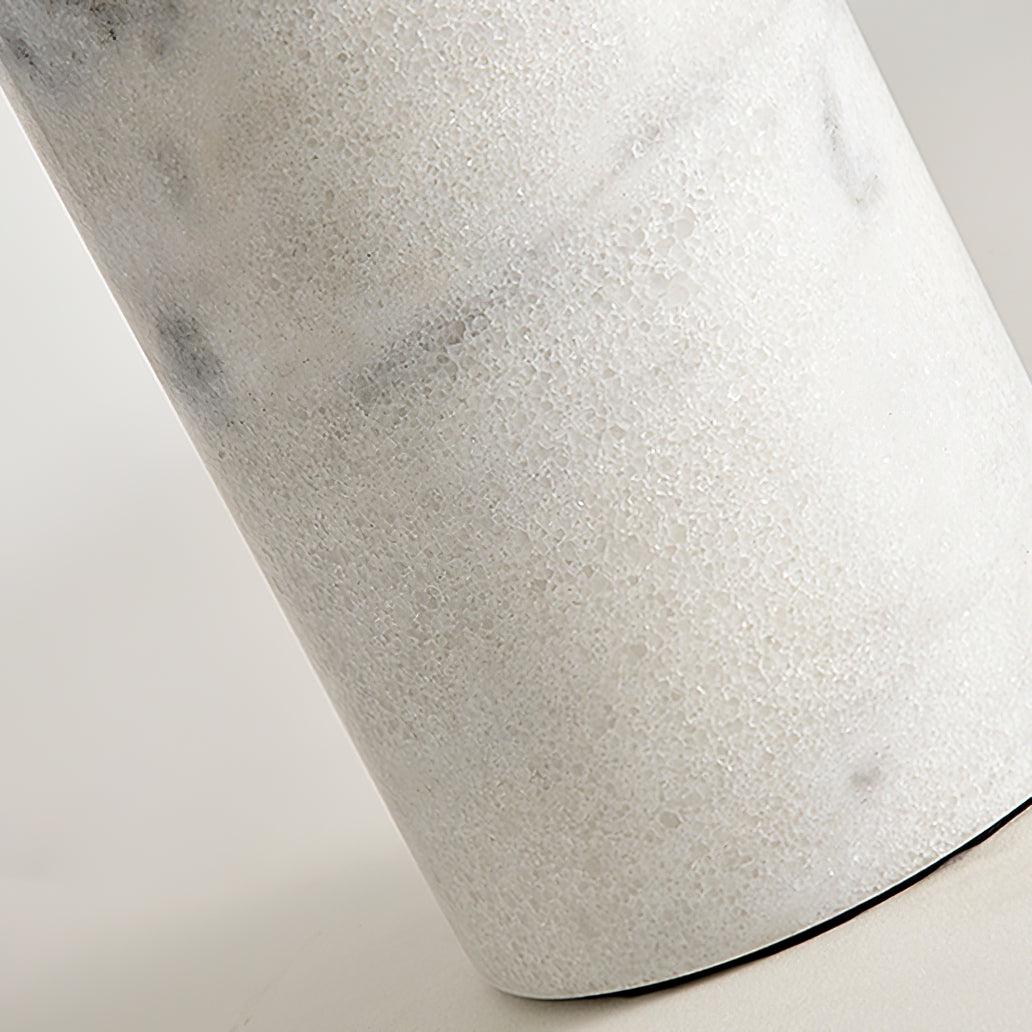 Extreme close-up of a Clérachic table lamp's white marble column, its grey-flecked surface showing the natural stone grain.