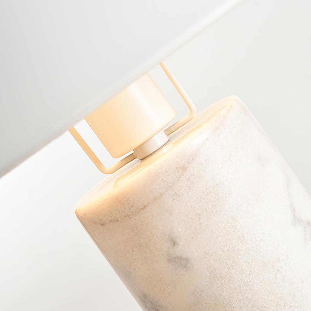 Tighter close-up of the same Clérachic lamp's bracket and glowing bulb, showing the grey veining of its marble column.