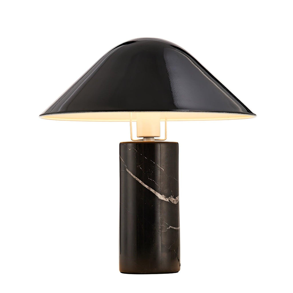Seen straight-on against a plain white studio background, a Clérachic black marble table lamp stands lit and centred.