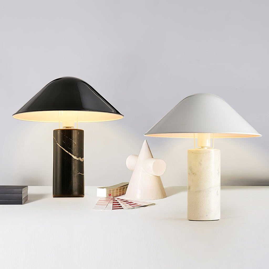Two Clérachic table lamps, one on a black marble base and one on white, standing together beside a paper cone ornament.