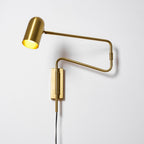 Swing arm wall lamp shown lit in a cozy interior