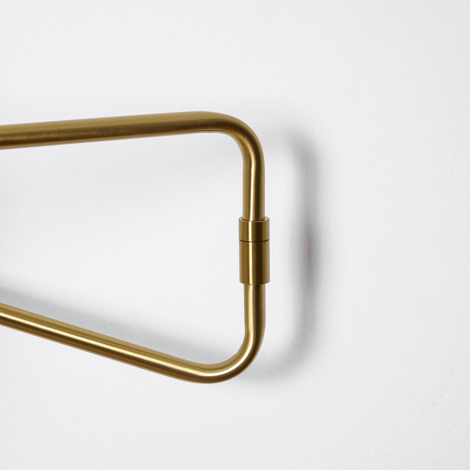 Swing arm wall lamp gold finish above a reading nook