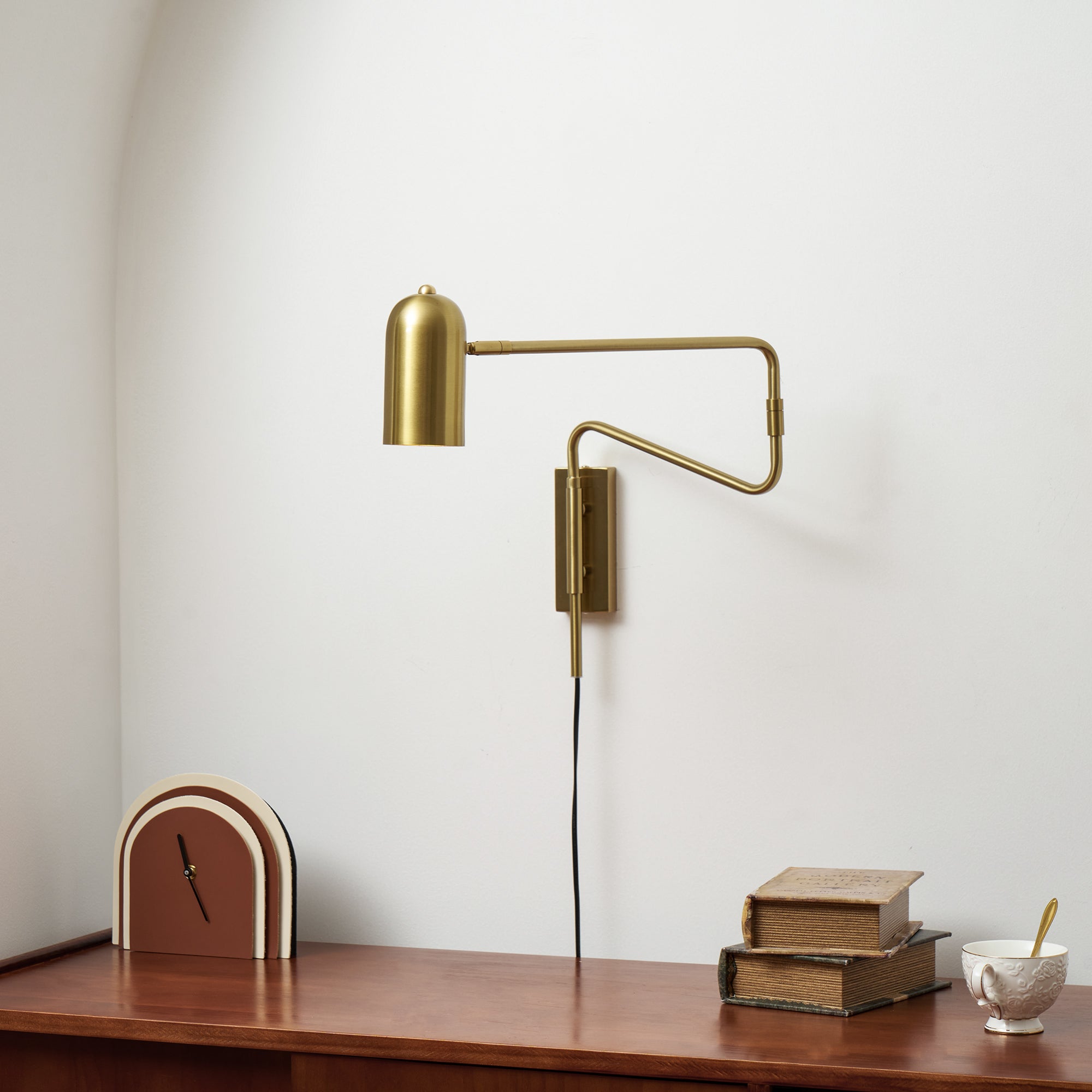 Swing arm wall lamp shown mounted beside a headboard